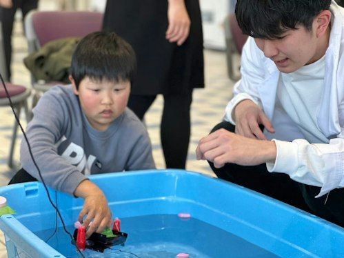 水中ドローンを操作する子ども
